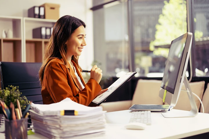 mulher no escritório usando prancheta e computador realizando pagamento de guias judiciais evintando a burocracia bancária graças a automação inovadora da Pag Útil