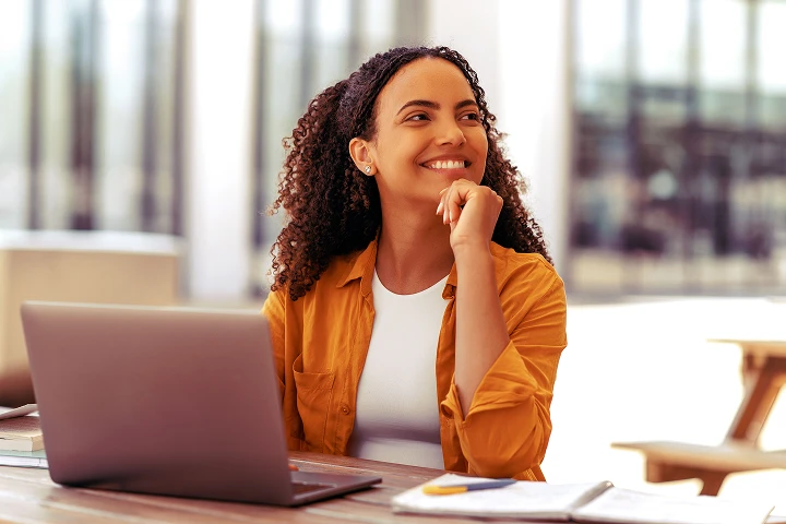 mulher sorrindo usando notebook utilizando o processo ágil desde a geração da guia até o pagamento da GNRE